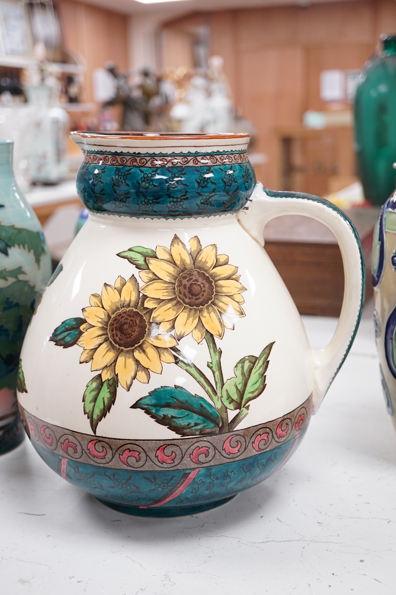 A Doulton stoneware Art Nouveau style vase, a Poole pottery vase and two other pieces, largest 27cm high. Condition - good